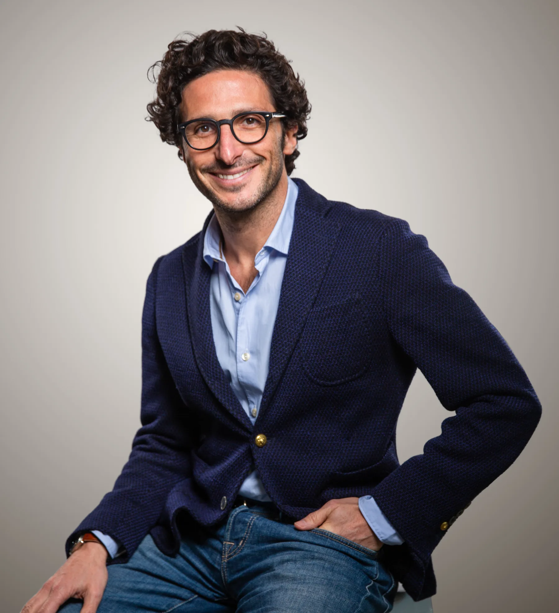 Adrien Nussenbaum, Mirakl CEO, smiling in a professional portrait, wearing a navy blazer and glasses against a neutral grey background